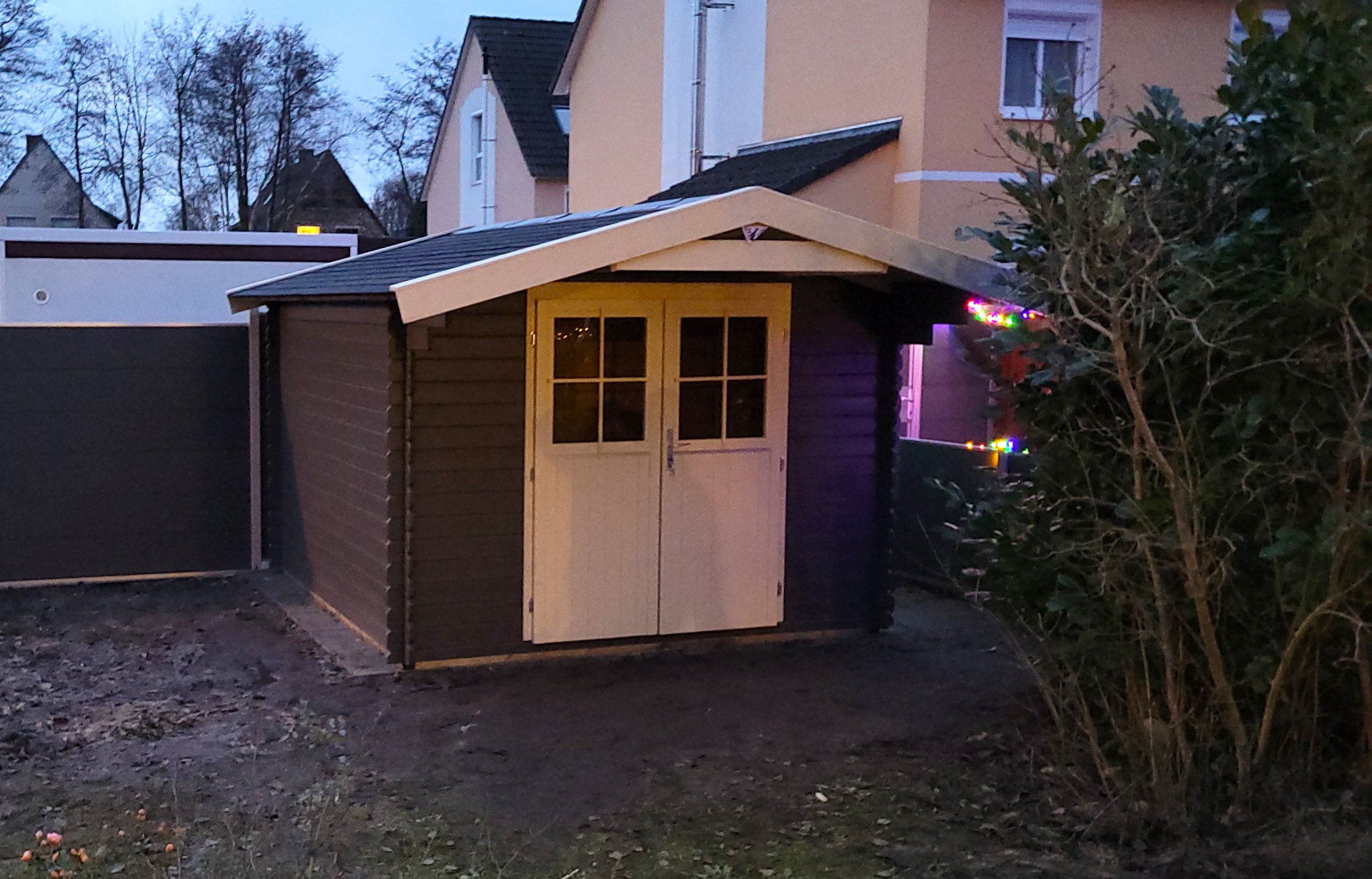 Fertige Gartenhütte in Dunkelgrau mit weißen Türfüllungen