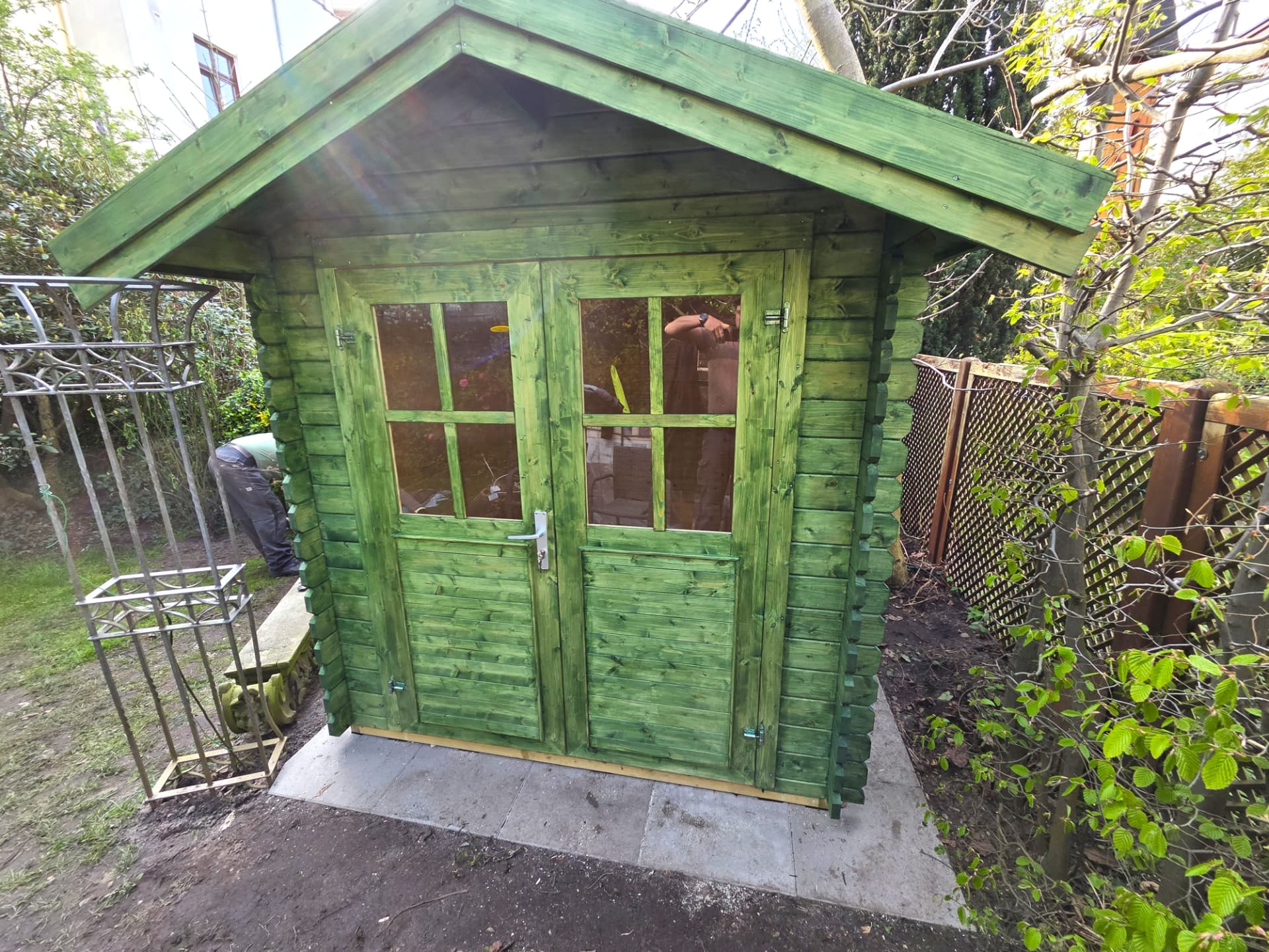 Fertige Gartenhütte in grüner Lasur auf Pflasterfundament